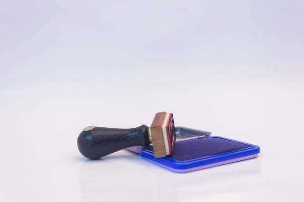 An old wooden stamp used in the office. Blank stamp on a white table. Light background.