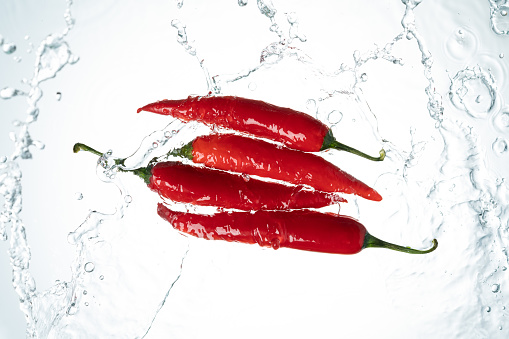 Red Chili Peppers Water Splash on White Background