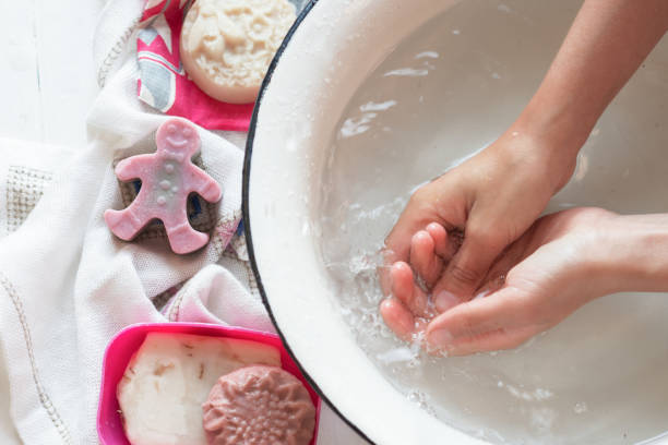 istock Child’s hands under white bowl with water upon water stream 1080301996