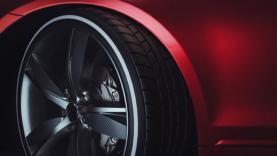 Modern new car rim on the car with visible brake disc and caliper - isolated against a white background