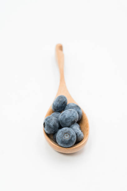 istock blueberry in the wooden spoon 1080308590