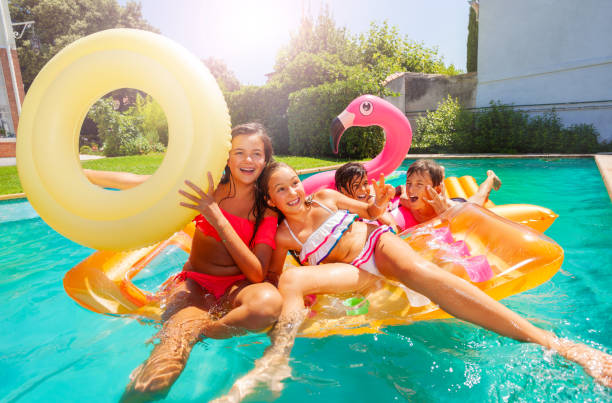 istock Happy teens playing with swimming floats in pool 1080308816