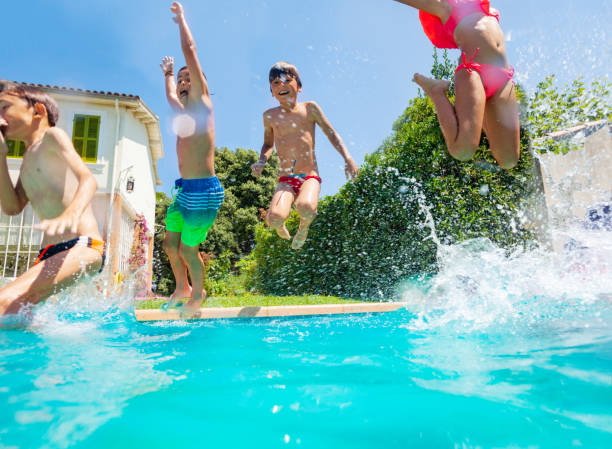 istock Happy friends jumping into the swimming pool 1080308870