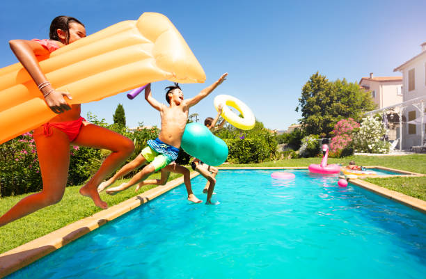 istock Funny teens with swim tools jumping into the pool 1080309242