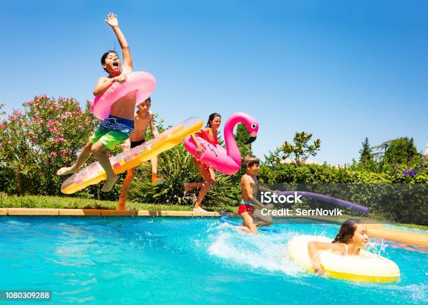 Happy Friends Jumping In Pool On The Vacations Stock Photo - Download Image Now - Swimming Pool, Child, Summer