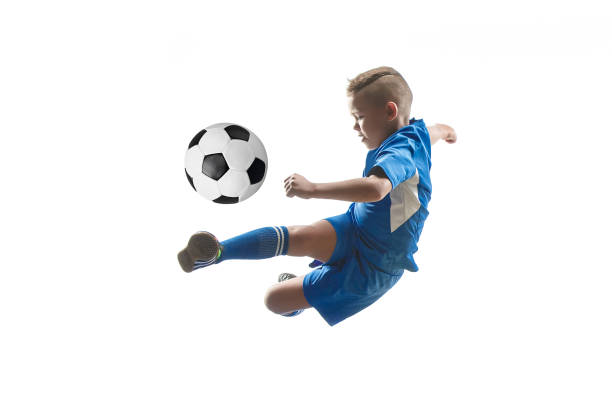 ragazzo con palla da calcio che fa calcio volante - little boys people indoors soccer foto e immagini stock