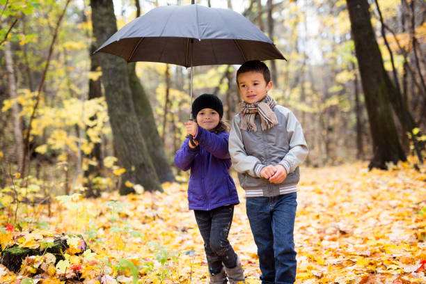 istock children playing in beautiful autumn park on cold sunny fall day. 1080310756