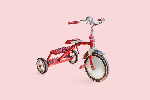 vintage kid red Tricycle on color background.