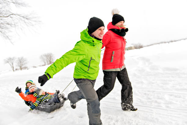 istock Cute Family Pulling Sledge Through Snowy Landscape 1080325436