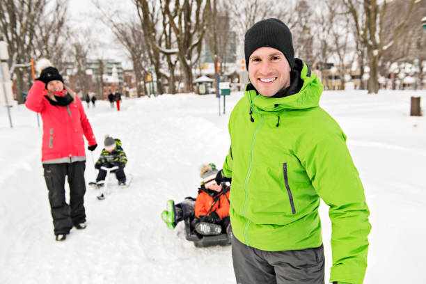 istock Cute Family Pulling Sledge Through Snowy Landscape 1080325572