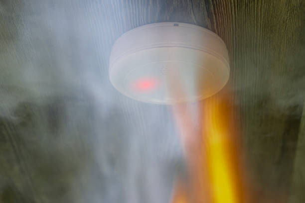 istock smoke detector with white smoke and red warning light 1080325594