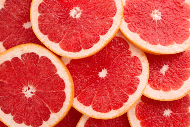 close-up grapefruit scheiben abstrakten hintergrund in lebenden korallen farbe. - close up macro stock-fotos und bilder