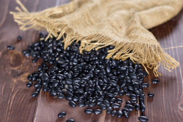 istock Raw black turtle beans on brown wood 1080327194