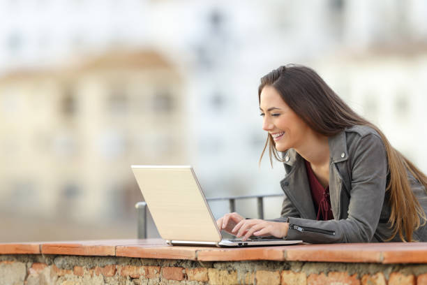 istock Happy woman using a laptop in a terrace 1080329510