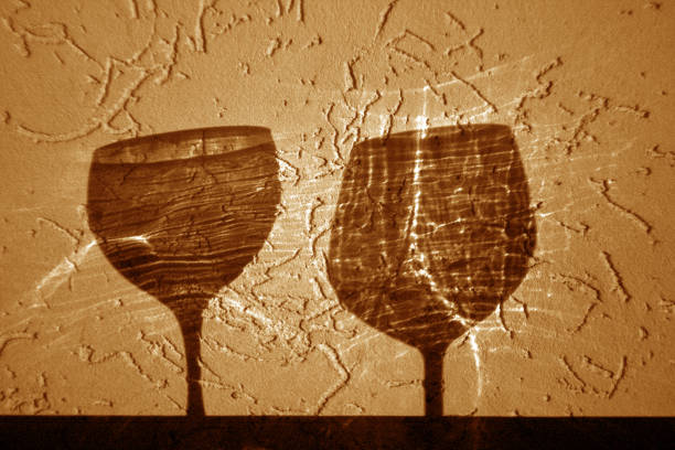 istock Two wine glasses shadow in orange tone 1080330406