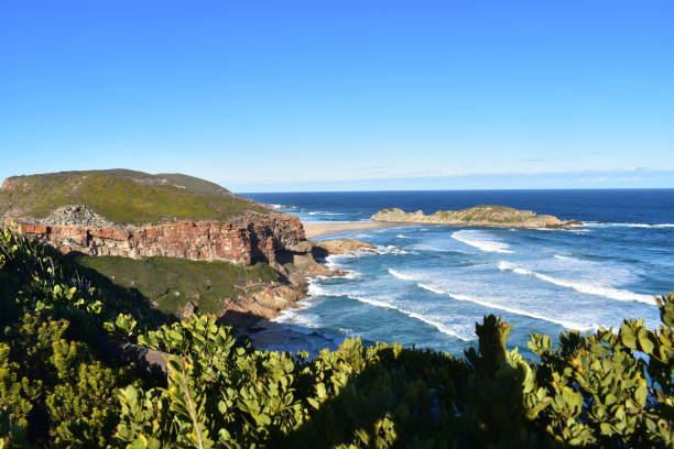 Magnificent landscape of Chapmanâs Peak, a prominent cliffside range in Western Cape, South Africa, surrounded by the sparkling Atlantic Ocean, offering spectacular vistas and highlighting the region's natural coastal beauty.
