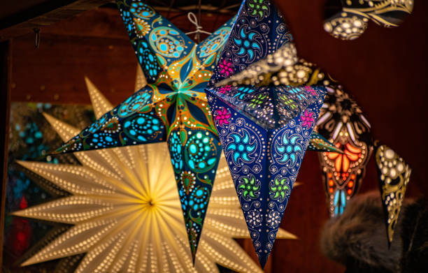 Christmas tree star baubles on a market stall Generic Christmas tree star baubles on a market stall at Birmingham German Christmas Market 2018. They are hung up underneath the roof of the stall. bullring stock pictures, royalty-free photos & images