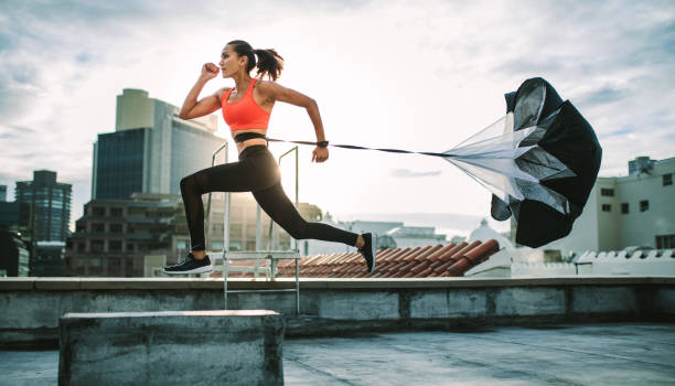 istock Woman running on rooftop with a resistance parachute 1080341866