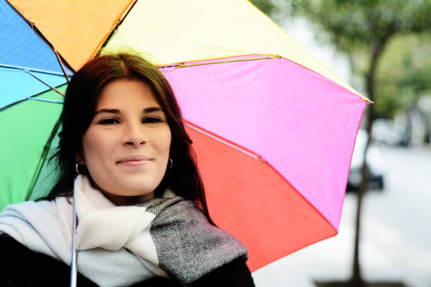 Portrait of a pretty middle-eastern woman in sunny and warm autumn or spring day. Young female posing with the umbrella