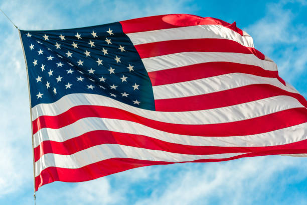 istock American flag waving in blue cloudy sky 1080351014