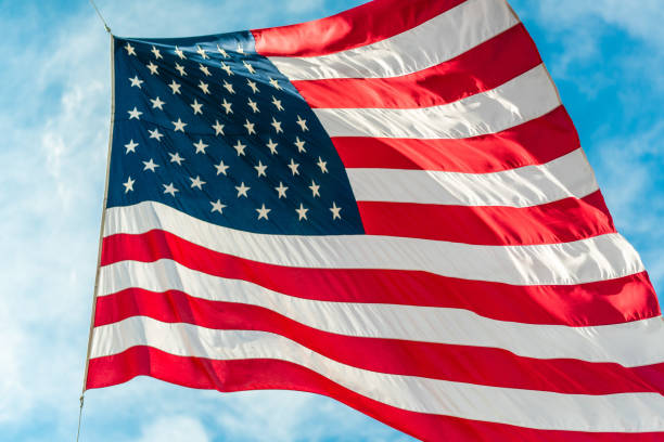istock American flag waving in blue cloudy sky 1080352662