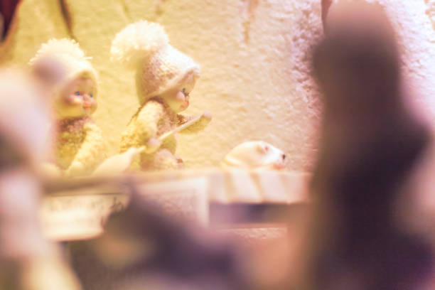 Two infant porcelain figurines paddling through a snow filled enviroment in a Christmas display