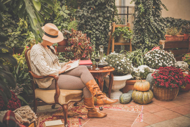 femme bénéficiant d’un livre et un automne coloré dans son back yard - autumn table setting flower photos et images de collection