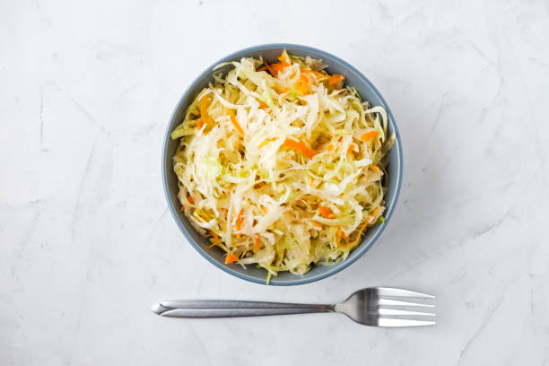 istock Fork and bowl of fermented cabbage on plaster surface 1080359076