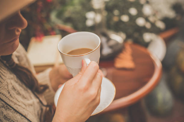 Close-up shot of a woman drinking coffee outdoors.