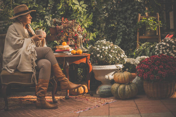 femme bénéficiant d’une journée ensoleillée dans back yard - autumn table setting flower photos et images de collection