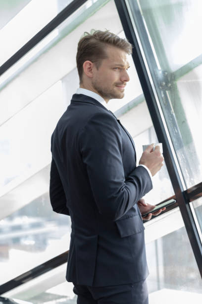istock Young businessman drinking coffee by the window 1080367760