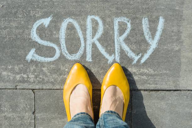 istock Female feet with text sorry written on asphalt 1080377054