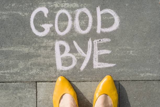 istock Female feet with text goodbye written on grey sidewalk 1080377698