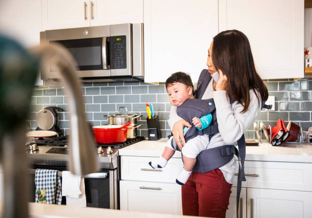 istock Mom wearing her baby while working in the kitchen 1080377864