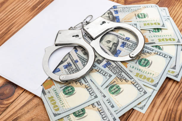 istock Envelope with money and handcuffs on the table. 1080384194