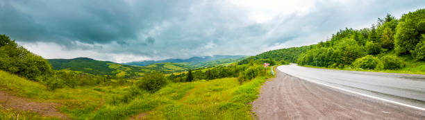 istock Road in mountains with dramatic sky and heavy clouds panorama 1080384848