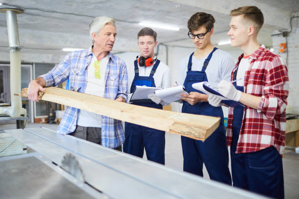 carpenter showing wooden plank to interns - trainee mechanic engineer student imagens e fotografias de stock