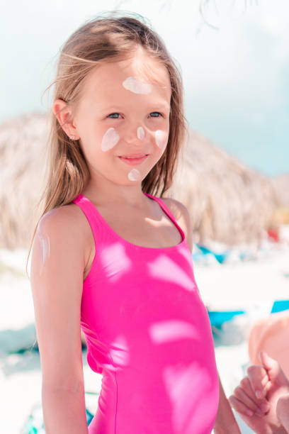istock Father applying sun cream to daughter nose. 1080386644