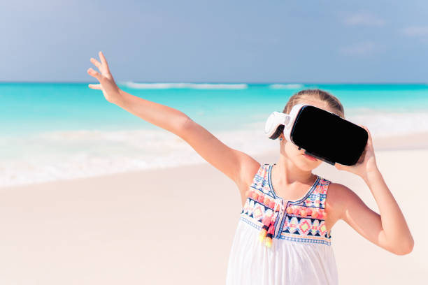 istock Kid wearing virtual reality glasses on beach 1080387878