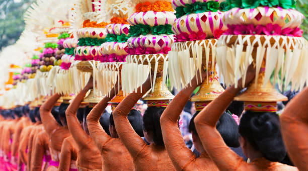 Balinese women with religious offering Group of beautiful Balinese women in costumes - sarong, carry offering for Hindu ceremony. Traditional dances, arts festivals, culture of Bali island and Indonesia people. Indonesian travel background indonesian ethnicity stock pictures, royalty-free photos & images