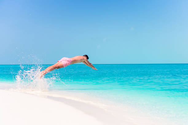istock Young man plunging into the turquoise sea 1080389034