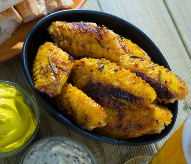 istock Fried chicken wings  served in black bowl, fresh sauses on table 1080389404