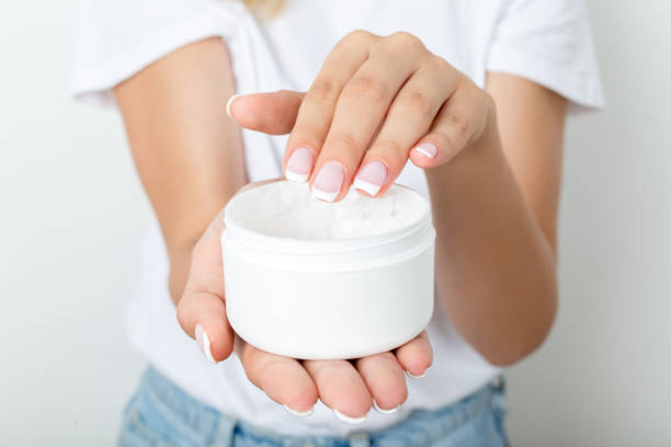 istock Young woman using moisturizing cream for soft skin 1080400778