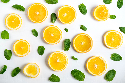 Background with slices of orange and mint leaves. Bright citrus background for banner, website. Pattern with oranges. View from above. Vitamin C.