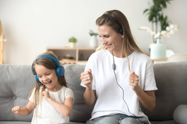 happy mother and child daughter listening to music in earphones - parent mother music listening imagens e fotografias de stock