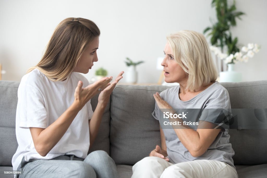 Angry young woman having disagreement with annoyed old mother Angry young woman has disagreement with annoyed old mother in law, grown daughter arguing fighting quarreling with senior elderly mom, different age generations bad relations family conflict concept Mother Stock Photo