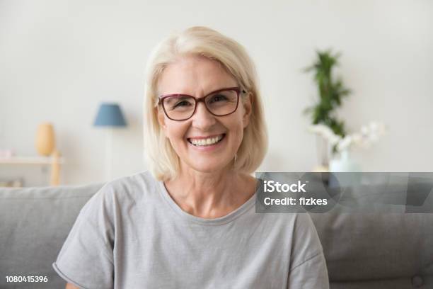 Sonrisa Medio Edad A Madura Mujer De Cabello Gris Mirando A Cámara Foto de stock y más banco de imágenes de Sonreír