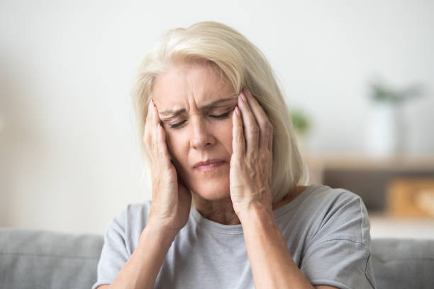 istock Upset older woman touching temples aching head feeling strong headache 1080415408