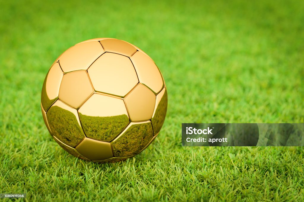 3D rendering: Golden Soccer ball / football lying on grass in a stadium, Big Business in sports, football, soccer. Gold - Metal Stock Photo