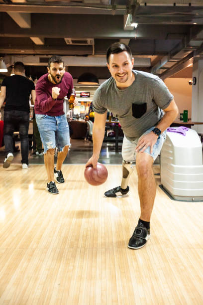istock Man with artificial leg bowling with friends 1080422948